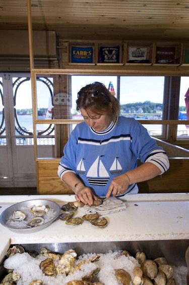 Phyllis Carr expertly shucks some oysters inside Carr's Oyster Bar, Stanley Bridge.