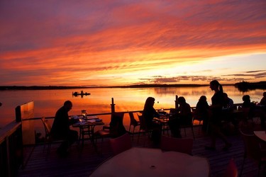 Diners enjoy a magnificent sunset from the decking at Clam Diggers Beach House & Restaurant, Georgetown on P.E.I.'s east coast.