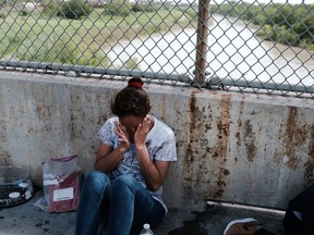 A Honduran woman, fleeing poverty and violence in her home country, waits along the border bridge after being denied entry into the U.S. from Mexico on June 25, 2018 in Brownsville, Texas.