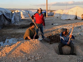 File: Displaced Syrians dig holes in a flooded camp near Dayr Ballut, Aleppo province, in northwestern Syria, on December 28, 2018. A Nanaimo, BC, man who went to Syria seeking
adventure has been detained in the war-ravaged country, and Canada's
foreign ministry says there is little it can do to help him.