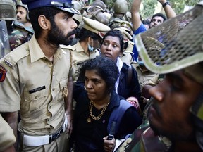 In this file photo taken on December 24, 2018 Indian police escort Hindu devotees Kanaka Durga, bottom, and Bindu, centre, after their group of women were stopped by hardline activists during an effort to reach the Sabarimala Ayyapa temple from Pamba in the southern state of Kerala.