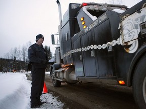 File: RCMP Const. James Spoor monitors contractors as they and representatives from Coastal GasLink proceed through the exclusion zone at the 27 kilometre marker towards the Unist'ot'en camp to remove barriers on a bridge over the Morice River, southwest of Houston, B.C., on Friday, January 11, 2019.