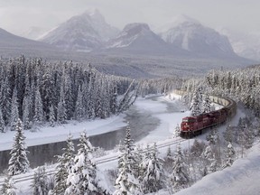 A Canadian Pacific freight train travels around Morant's Curve near Baker Creek, Alta. on Monday December 1, 2014. Heavy snowfall, warm temperatures and high winds have led to an extreme avalanche risk in Banff, Yoho, Kootenay and Jasper national parks.