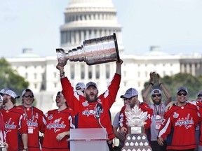 Alex Ovechkin of the Washington Capitals hoists the Stanley Cup during the NHL team's victory celebration on June 12 at the National Mall in Washington. The U.S. Capitol rises in the background.