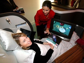 Jennifer Pearson gets a taste of first class luxury as Cathay Pacific flight purser Yvonne Gonzalez demonstrates the new first class seats on the company's new planes.
