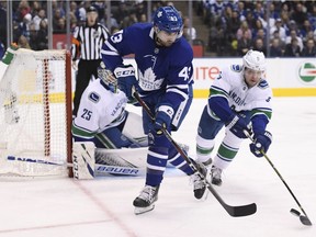 Toronto Maple Leafs centre Nazem Kadri (43) and Vancouver Canucks defenceman Derrick Pouliot (5) battle for the puck during first period NHL action in Toronto, Saturday, Jan. 5, 2019.