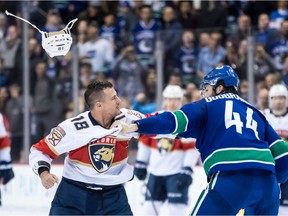 Micheal Haley loses his helmet as he and Vancouver Canucks' Erik Gudbranson fight during the first period.