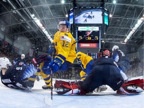 Sweden's Erik Brannstrom battles with United States' Tyler Madden and goaltender Kyle Keyser during 2019 IIHF World Junior Hockey Championship game action in Victoria, on Saturday, December 29, 2018.
