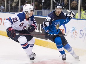 United States' Noah Cates (21) fights for control of the puck with Finland's Oskar Laaksonen (2) during second period IIHF world junior hockey action in Victoria, Monday, Dec. 31, 2018.