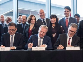Premier John Horgan and senior ministers looked on with Prime Minister Justin Trudeau as company officials sign a final investment declaration to build the LNG Canada export facility on Oct. 2, 2018.