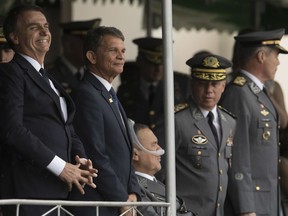 In this Dec. 1, 2018 photo, Brazil's President-elect Jair Bolsonaro, left, and Minister of Defense, Gen.Joaquim Silva e Luna, attend a graduation ceremony at the Agulhas Negras Military Academy in Resende, Brazil. "I am very happy to be in this house that formed me. I owe almost everything in this life to the beloved Brazilian army," said Bolsonaro, during the ceremony.