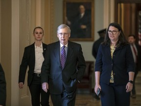 Senate Majority Leader Mitch McConnell, R-Ky., with Secretary for the Majority Laura Dove, right, walks from the chamber at the Capitol in Washington, Wednesday, Jan. 23, 2019. The Senate will vote on two competing proposals this week to end the partial government shutdown, but neither seems to have enough votes to advance.