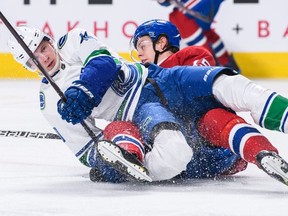 Vancouver Canucks centre Elias Pettersson, left, twists his right ankle while falling on Montreal Canadiens centre Jesperi Kotkaniemi during NHL action Jan. 3 at the Bell Centre in Montreal.