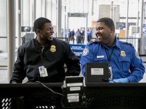 Transportation Security Administration officers Tyrone Rawls, left, and Ashad smile at a security checkpoint at Austin-Bergstrom International Airport in Austin, Texas, Friday, Jan. 25, 2019, moments President Donald Trump announced a deal with Congress to reopen the federal government.