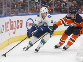 Vancouver Canucks' Jay Beagle, right, and the Oilers' Adam Larsson battle for the puck during NHL action in Edmonton on Dec. 27, 2018.