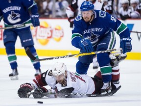 Canucks' Alex Biega (55) checks Arizona Coyotes' Brad Richardson during NHL action in Vancouver on April 5, 2018.