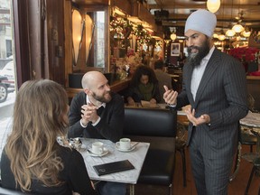 NDP Leader Jagmeet Singh speaks to a man and a woman in a coffee shop during a tour of the Montreal borough of Outremont, Saturday, December 22, 2018, ahead of federal byelection which is expected to be called in early 2019.