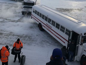 Passengers leave a plane and board buses to change planes in Happy Valley-Goose Bay, N.L., on Sunday, Jan. 20, 2019. An end is finally in sight for passengers who spent about 16 gruelling hours on a plane grounded at an airport in frigid Happy Valley-Goose Bay, Labrador.