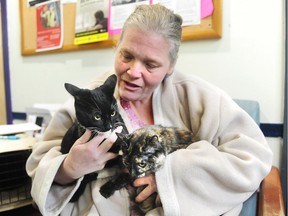 Virginia Stover with her two cats, Mr. Pickles, left, and Flick, at a free animal health-care clinic for those who have no, or low income, in Vancouver on Jan. 29.