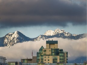 North Shore mountains are partially obscured by a veil of cloud as seen from Vancouver, BC.