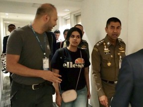 In this Jan. 7, 2019, file photo released by the Immigration Police, Chief of Immigration Police Maj. Gen. Surachate Hakparn, right, walks with Saudi woman Rahaf Mohammed Alqunun before leaving the Suvarnabhumi Airport in Bangkok, Thailand. Australia says it is considering granting the Saudi who fled from her family refugee resettlement based on referral by the U.N.
