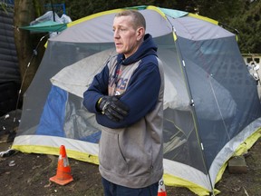 Ron Moore stand outside the tent where he's been living behind apartment towers on Bidwell Street in Vancouver's West End.