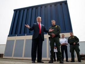 In this March 13, 2018, file photo, President Donald Trump talks with reporters as he reviews border wall prototypes in San Diego.