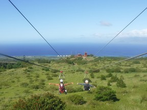 With the resort of Kaanapali in the distance, the author and his wife catch some Maui air on the only dual zipline course on the Hawaiian island.