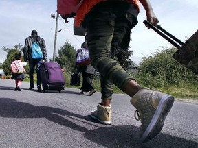 A family approaches the unofficial border crossing at the end of Roxham Rd. in Champlain, N.Y. (Charles Krupa/AP)