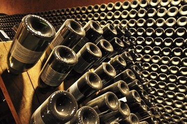 Bottles of Champagne on wooden riddling racks.