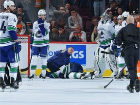 Medical personnel attend to an injured Alex Edler of the Canucks against the Philadelphia Flyers.