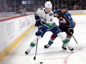 DENVER, COLORADO - FEBRUARY 27: Elias Pettersson #40 of the Vancouver Canucks fights for the puck against J.T. Compher #37 of the Colorado Avalanche in the first period at the Pepsi Center on February 27, 2019 in Denver, Colorado.