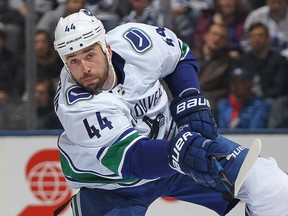 Defenceman Erik Gudbranson of the Vancouver Canucks fires the puck up ice during a January 2018 NHL game in Toronto against the Maple Leafs.