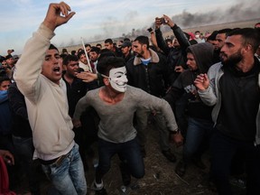 Palestinian protesters shout slogans during clashes with Israeli forces near the border with Israel, east of Khan Yunis, in the southern Gaza Strip, on April 2, 2018.