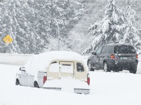 Vehicles make their way along the snow-covered highway in Victoria, B.C., Tuesday, Feb. 12, 2019. A winter storm has pounded British Columbia's capital as well as Vancouver and the lower mainland.