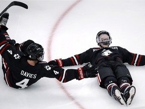 Northeastern forward Tyler Madden, right, makes snow angels as he celebrates his game-winning goal against Boston University with Jeremy Davies in overtime during the first round of the Beanpot NCAA college hockey tournament in Boston.