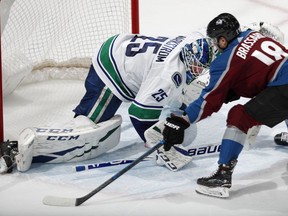 Vancouver Canucks goaltender Jacob Markstrom, left, stops Colorado Avalanche center Derick Brassard during the shootout of an NHL hockey game Wednesday, Feb. 27, 2019, in Denver. The Avalanche won 3-2.