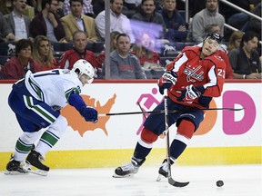 Dmitrij Jaskin fights for the puck with Canucks defenceman Ben Hutton, who will be needed more than ever.