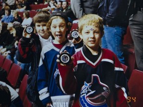 Braedon Arcand, Brayden Low and Troy Stecher show off the pucks they were given while attending a Canucks game as kids.