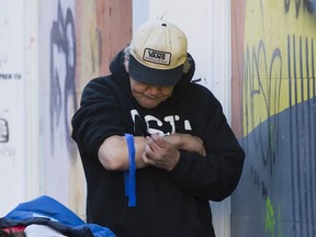 A man injects drugs in Vancouver's Downtown Eastside, Wednesday, Feb. 6, 2019. Despite significant efforts to combat overdose deaths in British Columbia, the provincial coroner says illicit drug overdose deaths increased to 1,489, just over the 2017 death total.