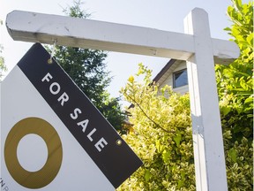 A For Sale sign hangs from one point and twists in the wind on East Broadway between Victoria and Nanaimo, in this July 2017 file photo.