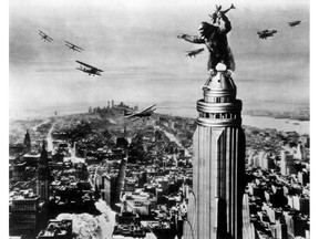 King Kong swats attacking airplanes from atop the Empire State Building.