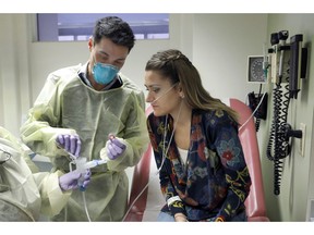 Ella Balasa, 26, of Richmond, Va., who has cystic fibrosis, and antibiotic-resistant bacteria lodged inside her CF-damaged lungs, watches as Yale University researcher Benjamin Chan, pours a bacteriophagen he developed for her to inhale, at the Winchester Chest Clinic, in New Haven, Conn., Thursday Jan. 17, 2019.