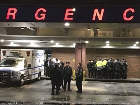 New York City police officers gather at Jamaica Hospital in the Queens borough of New York after a few NYPD officers while responding to a robbery in a mobile phone store on Tuesday, Feb. 12, 2019.