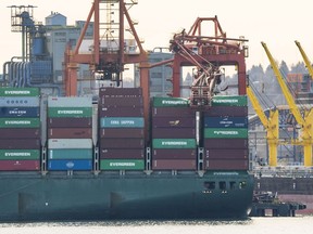 A tug holds the container ship Ever Summit up against the dock after a crane collapsed and rests on top of a stack of containers while docked at Global Container Terminal in Vancouver, BC, January, 28, 2019.