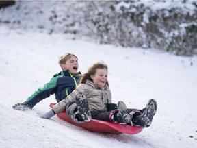 VANCOUVER, B.C.: FEBRUARY 11, 2019 – Lily Greer (front) and George Sale scream out while sliding down a hill at Queen Elizabeth Park while enjoying a snow day in Vancouver, B.C. on February, 11, 2019.