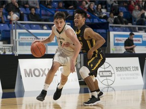 Oak Bay Bays' Diego Maffia tries to get past Burnaby South Rebels' Eubert Ayangwa during quarter-final action in the Quad-A B.C. high school boys' provincial basketball championship at the Langley Events Centre.