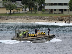 In this April 14, 2013, file photo, a group of Vietnamese asylum seekers are taken by barge to a jetty on Australia's Christmas Island.