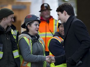 Prime Minister Justin Trudeau greets workers as he tours the Conrad rental housing development in Vancouver, Monday, Feb. 11, 2019.