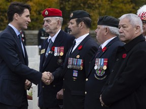 Prime Minister Justin Trudeau speaks with Canadian veterans following a ceremony at the Canadian Cemetery No. 2 near Vimy Ridge, France, in 2018.